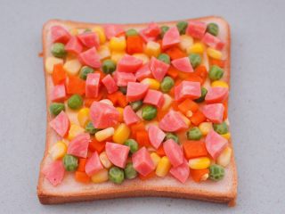 8、田园时蔬吐司披萨,再撒上火腿丁。