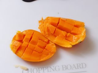 4、芒果苹果奶昔,把芒果切开后先去核,再在芒果肉上切方格。