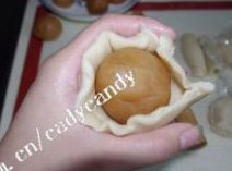 12、苏式栗子莲蓉月饼,将面皮用手按扁，包入馅，用手的虎口往上收，收紧面皮捏紧封口