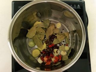 11、红烧羊肉,炖锅烧热后加入1小勺大豆色拉油,油烧热后加入姜片和葱段,香叶和花椒粒炒出香味