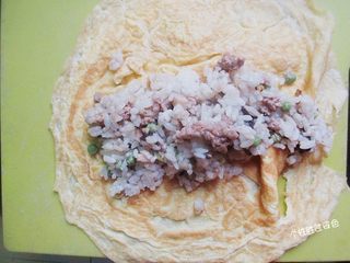 9、蛋皮包饭,把一份炒好的饭放在蛋皮中央，把蛋皮的两边翻起，向中间褶，把饭包起來。