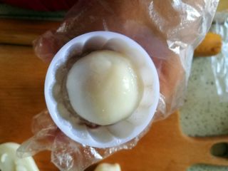 13、花样紫薯冰皮月饼,模具内撒少量手粉,放入月饼胚,用手指按压后挤出即成。