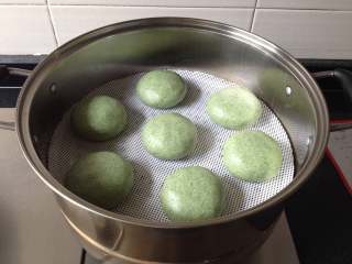 10、清明粑,放进蒸锅里(蒸锅中事先垫上不粘垫,或在每个饼的下面垫上菜叶防粘),大火将水烧开,转中火蒸12分钟