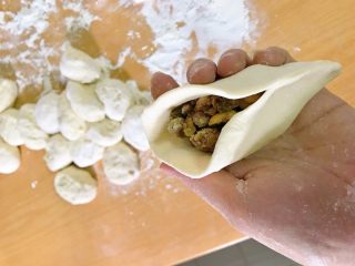 15、红糖伍仁馅糖三角,对折，一头捏起，捏到接近中间。开口部分，向中间推，捏住。