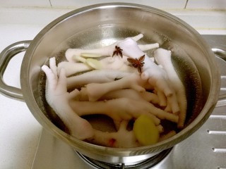 4、韩式辣酱鸡爪,锅中放入凉水，放入鸡爪加入一个八角，几片姜片。