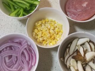 8、鲜虾火腿披萨,8.青椒和洋葱切丝，香菇切薄片，玉米粒直接切下来就可以了，火腿切小块。