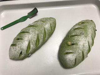 15、抹茶干果软欧,表面撒粉,用锋利的刀割出口子。