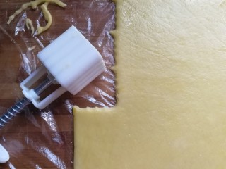 8、玉米油版酥性饼干,擀好后将保鲜膜剪开，用饼干模具或月饼模具开始压模（有饼干模具最好，我没有印花饼干模具，就用月饼模具代替）