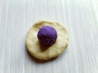 9、#感恩节食谱#南瓜紫薯馅饼,取小块面团,用手心压扁,放上做好的紫薯馅。虎口手法包起来。
