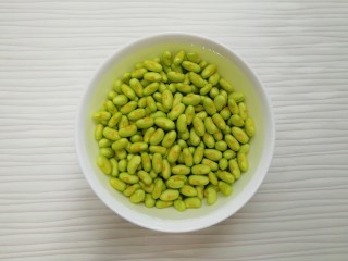 5、冬至美食  毛豆炒鸡丁,将剥好的豆子放入水里，用手轻轻的搓一下，洗去毛豆上面一层像膜一样的东西，控一下水分备用。