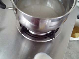 3、转化糖浆-月饼专用,将水放锅里搅拌均匀，放在炉灶上中火烧开。