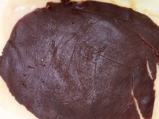 21、驴打滚,放入保鲜袋中擀成和糯米皮差不多大小的长方形，剪开保鲜袋，将红豆沙片放在糯米皮上