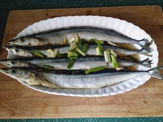 2、烤秋刀鱼,秋刀鱼去内脏、头腮洗净,加葱姜、料酒腌制30分钟左右便于入味