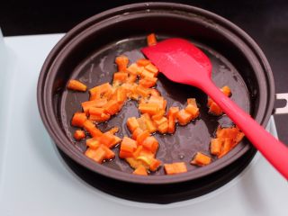 4、补钙又营养的虾仁豆芽蛋炒饭,锅烧热后重新加入15克花生油,把胡萝卜丁先用小火慢慢炒至变软后。