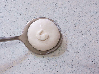 14、萌系汪汪。【豆香柴犬汤圆】,刚才是柴犬的头部，现在来做柴犬的屁股。取 0.5g糯米面团，搓成一头粗一头细的形状，再整理成弯曲的尾巴造型，摆到大团子上