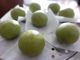 9、蛋黄肉松青团（麦青粉版）,包好的青团放硅油纸上，放在蒸格上。