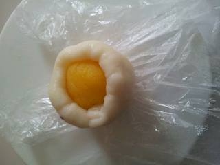 8、素冰皮,把模具撒上熟粉倒掉多余的粉，戴上一次性手套，面皮用手压圆包入馅料，收好口。