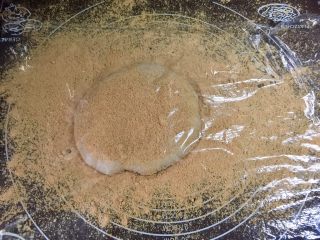 5、北京+驴打滚,把糯米团放在揉面垫上，再撒一些黄豆粉防粘，铺上一张保鲜膜，也是为了防粘，因为没有加油的糯米蒸熟了真的特别粘。