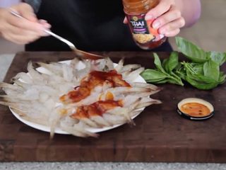 3、极简单做几个泰国爆竹虾,将虾排放在盘子上，尾巴朝向一个方向。将准备好的泰国酱放在虾上，腌制几分钟，期间避免腌到尾巴。