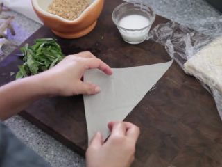 7、极简单做几个泰国爆竹虾,用湿毛巾盖住解冻的春卷皮，使其保持湿润。取一张春卷皮，三角形顶端朝右