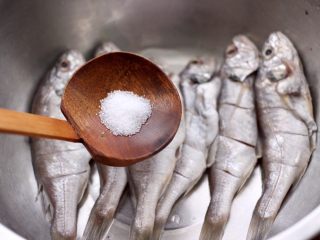 5、香辣孜然烤鱼,把改好花刀的鱼,放入盆中,加入适量的盐。