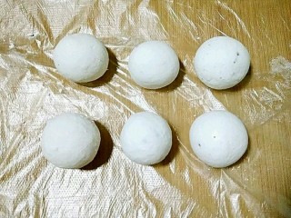 22、桂花黑芝麻汤圆（纯手工无油低糖版）,团好的汤圆放在保鲜膜上防粘。
