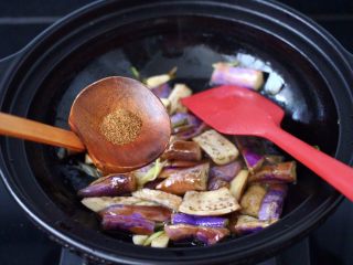 10、干煸烤肠茄条双椒,加入花椒粉调味，大火继续翻炒至茄条断生变色。