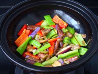 11、干煸烤肠茄条双椒,加入切条的青红尖嘴，大火继续快速翻炒均匀。