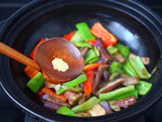 12、干煸烤肠茄条双椒,再放入鸡精增加口感。