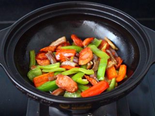 15、干煸烤肠茄条双椒,看见青红尖椒断生变色，即可关火。