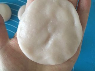 9、Q弹奶黄冰皮月饼,将一个剂子按成圆饼，中间厚点边缘薄点
