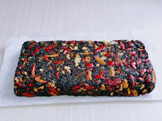 11、芝麻核桃糖,翻出来，放入烤盘中，戴上食品手套整形，用力压，一定要压紧，压实，晾凉，一定要凉透。