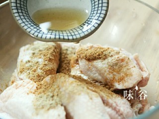 4、烤鸡翅,倒入料酒。