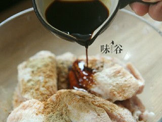 5、烤鸡翅,倒入酱油。