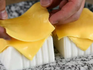 2、超美味的芝士豆腐做法 五分钟就搞定,将两片芝士，交叉铺在豆腐上