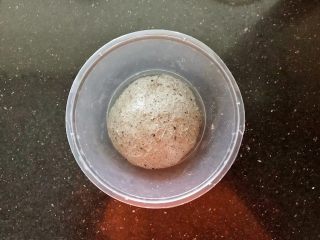 3、黑芝麻吐司(一次发酵),把面团放入保鲜碗中盖上盖子放入冰箱冷藏4个小时以上。(可以头天晚上制作好放入冰箱冷藏保存,第二天拿岀来回温后继续下面的制作程序)