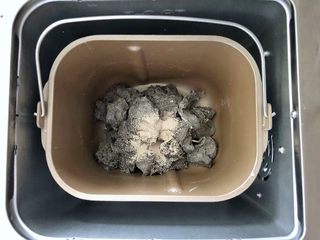 5、黑芝麻吐司(一次发酵),面团剪成小块放入面包机中,接着放入干酵母。