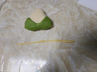 11、端午节手工粽心造型软欧包,取黄色面团擀成长条