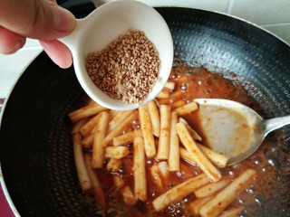 12、韩式辣炒年糕，炙手可热的小吃,年糕条炒软，最后倒入芝麻。