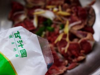 4、健脾消食的蒜苗爆鸡胗,把所有的鸡胗都改好刀以后，放到一个大一点的碗里，这个时候加入少许盐和半个鸡蛋清，再加入料酒和甘汁圆的玉米淀粉。