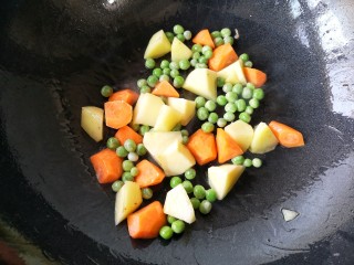 14、日式咖喱鸡排饭,另起锅，倒入适量的油烧至7成热。下入胡萝卜，土豆和青豆翻炒一下。