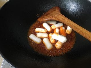 3、韩式年糕,开大火加入年糕炒均匀。