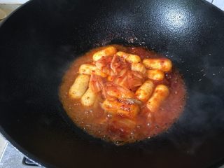 6、韩式年糕,年糕和泡菜炒均匀后,加入少许水加盖煮熟。