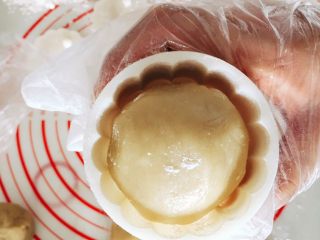 16、木糖醇栗子蓉月饼,把抹过面粉的部分轻轻的扣进模具里，这里说一下，放进去前把饼轻轻搓成圆柱形，这样好放很多。