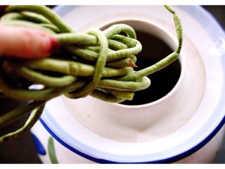 8、绿色美食+自制酸豆角,加入晾干后的豆角、我是 把豆角卷起来放入罐里的、这样罐罐里面可以节省空间哟、这是小技巧
