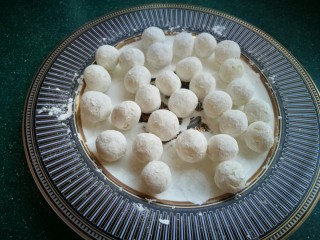 9、椒盐小土豆球,然后只需轻轻晃动盘子，每个土豆球的全身就均匀的裹上了一层淀粉，不用单独一个个的裹淀粉了。锅里油烧热后放入土豆球，炸至金黄时捞出控油。