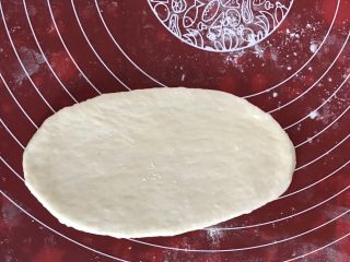 8、日式面包卷,取一个醒发好的面团擀成长舌状