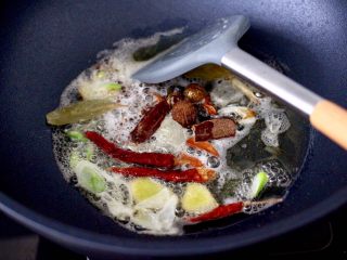 6、啤酒香卤鹌鹑蛋,韩国VCC的锅烧热后，油温6成热时、放入冰糖，姜片和葱白爆香，再加入八角、香叶、桂皮、草寇，花椒和干辣椒小火慢慢炒香。