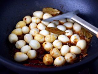 9、啤酒香卤鹌鹑蛋,加入剥壳的鹌鹑蛋，混合所有的食材和调料翻炒均匀。