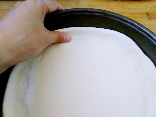 12、八寸披萨饼饼胚,披萨盘底刷油，把饼放入盘中，用大拇指把饼的边缘推高。